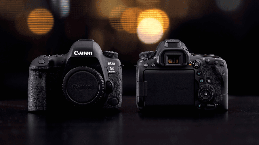 Two Canon EOS 6D Mark II DSLR cameras displayed on a dark surface, one showing the front with the lens cap on and the other showing the back with the LCD screen and controls