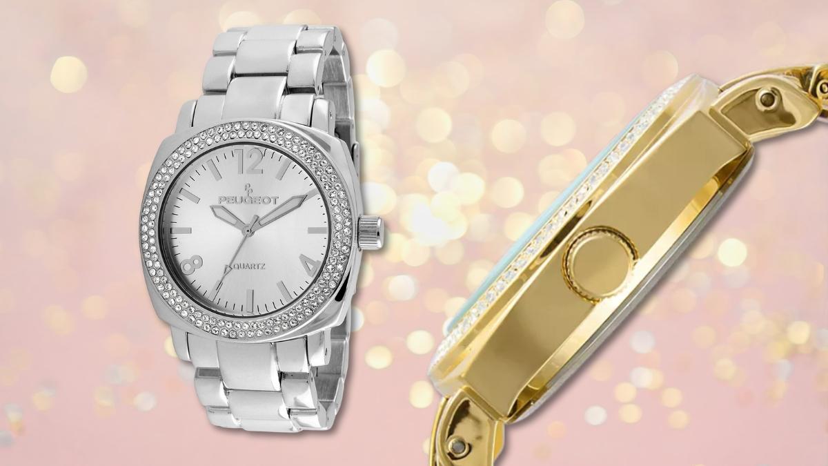 Silver and gold Peugeot women’s watch with a Swarovski crystal bezel shown on a soft pink bokeh background.